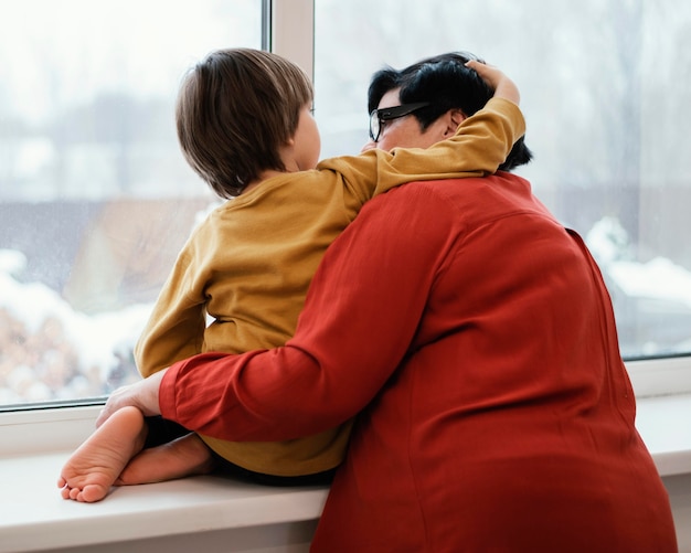 Foto gratuita abuela y nieto mirando por la ventana juntos