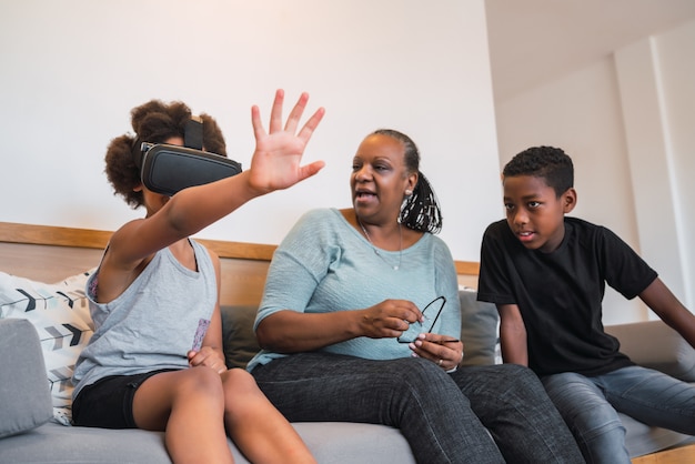Abuela y nietos jugando junto con gafas de realidad virtual.
