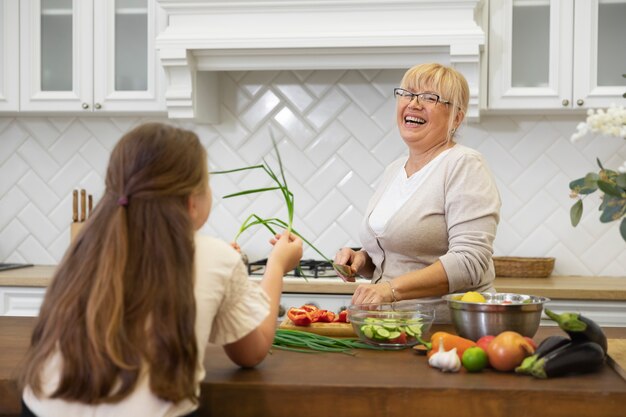 Abuela y niña de tiro medio con comida