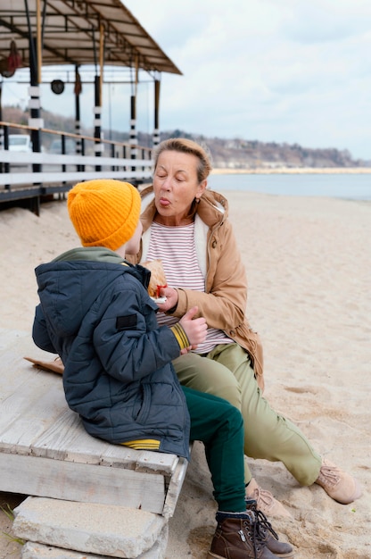 Foto gratuita abuela y niño de tiro completo en la playa