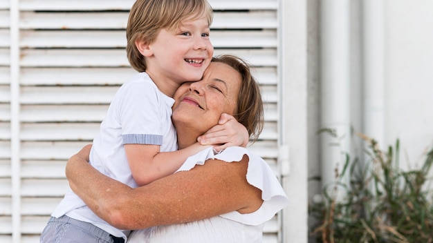 Abuela y niño de tiro medio abrazándose