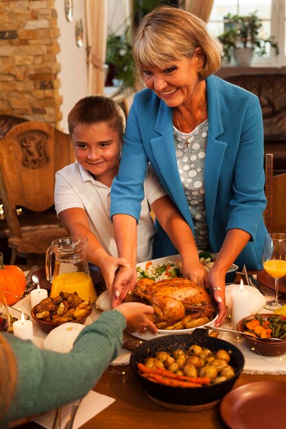 Abuela y niño de tiro medio en la cena