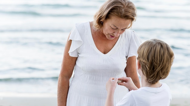 Abuela y niño de tiro medio en la playa