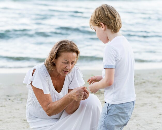 Abuela y niño de tiro medio en la playa