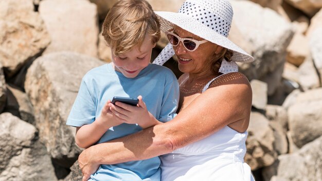 Abuela y niño de tiro medio con teléfono