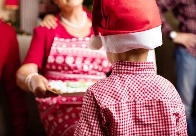 Abuela ofreciendo a su nieto galletas de navidad