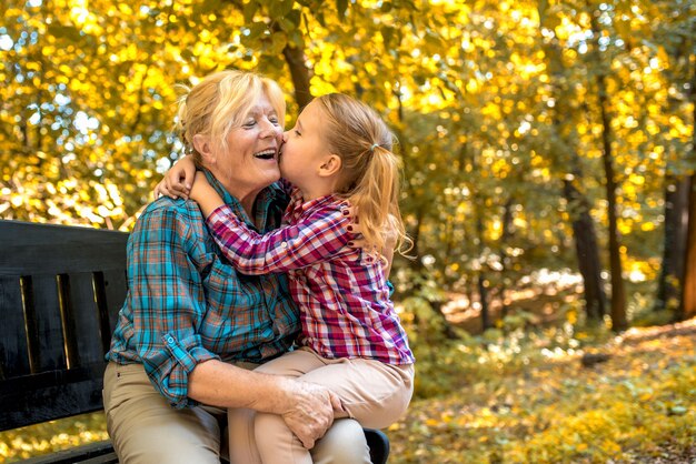 Abuela sonriente abrazando a su nieta en el parque