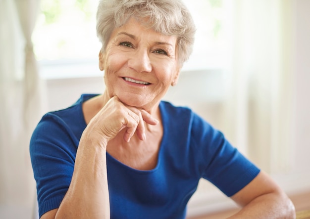 Abuela sonriente sentada en la mesa