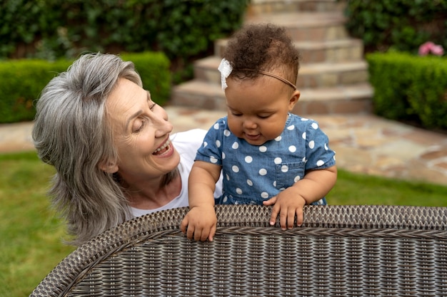 Abuela sonriente de tiro medio con bebé