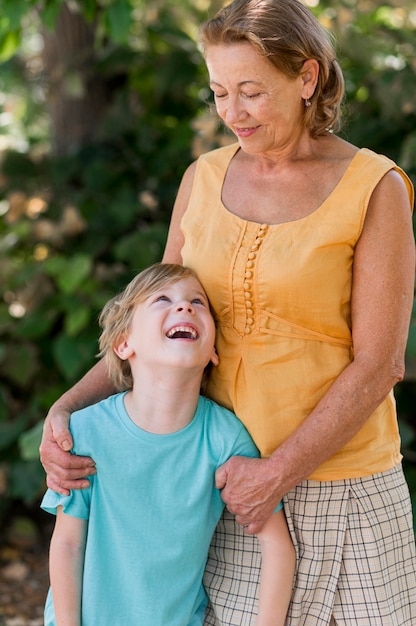 Abuela sonriente de tiro medio mirando kid