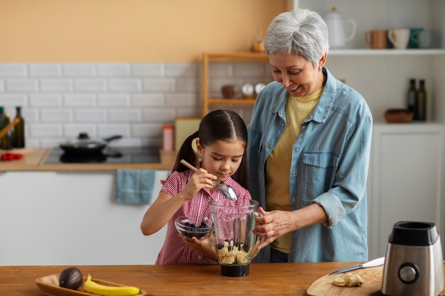 Foto gratuita abuela de tiro medio y niña cocinando juntas