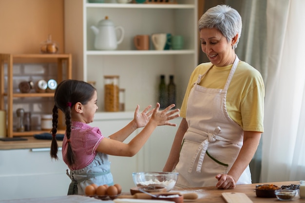 Foto gratuita abuela de tiro medio y niña cocinando juntas