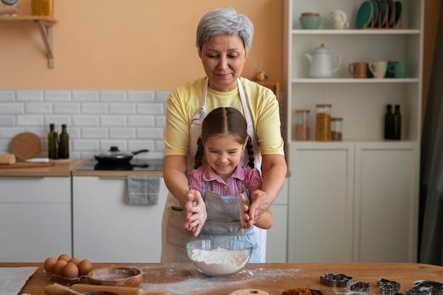 Foto gratuita abuela de tiro medio y niña cocinando juntas