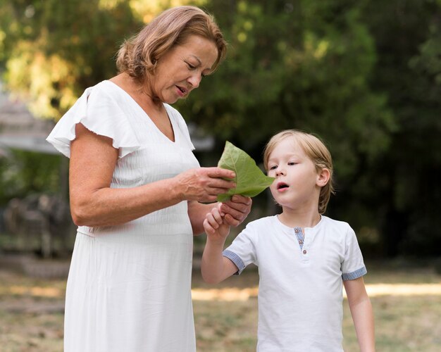 Abuela de tiro medio y niño con hoja