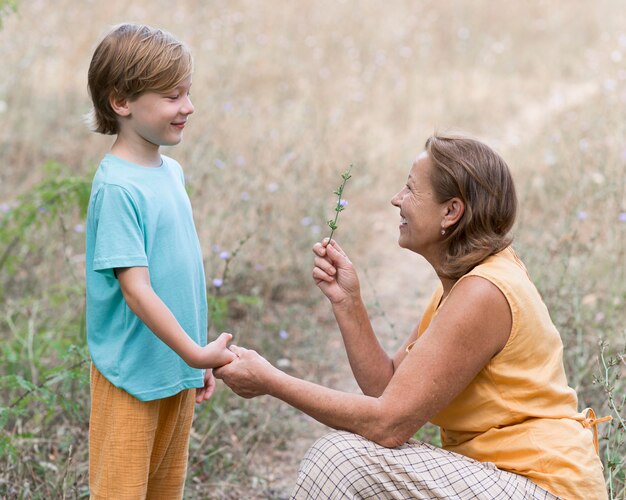 Abuela de tiro medio sosteniendo flor