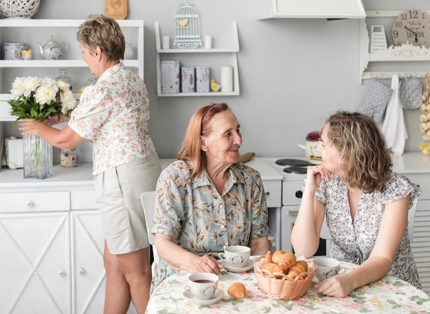 Foto gratuita abuelita y nieta conversando mientras desayunan