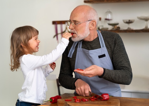 Foto gratuita abuelo cocinando en la cocina con su nieto