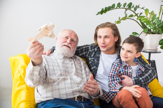 Abuelo feliz jugando con avión de madera