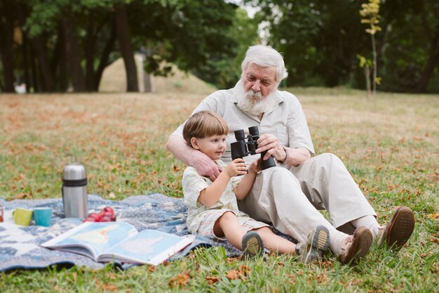 Abuelo mostrando binoculares a nieto