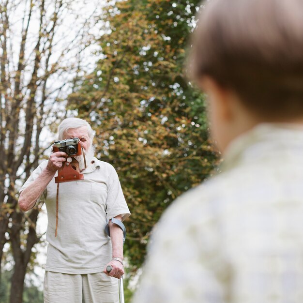 Abuelo con nieto al aire libre tomando fotos