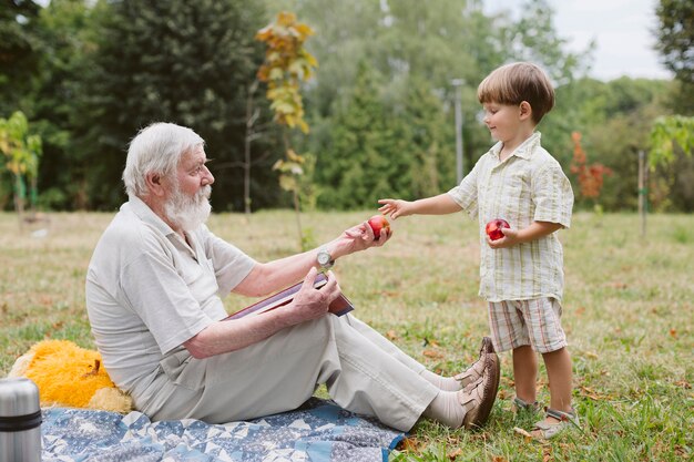 Abuelo y nieto en picnic en la naturaleza