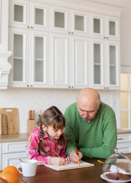 Foto gratuita abuelo y niña de tiro medio en la cocina