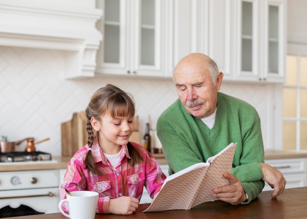 Foto gratuita abuelo y niña de tiro medio en el interior