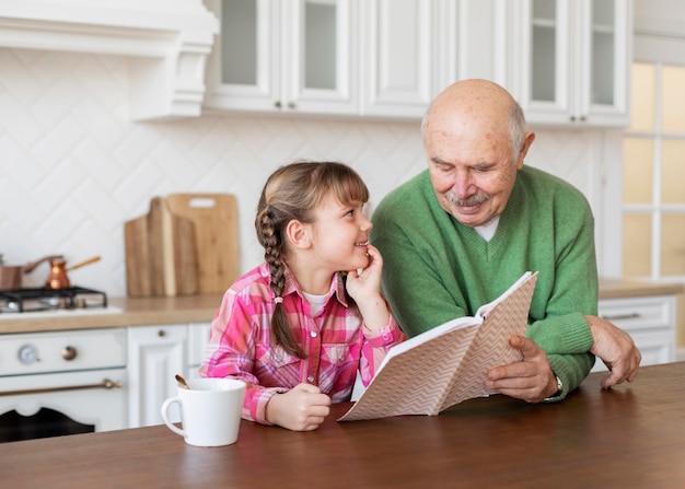 Foto gratuita abuelo y niña de tiro medio con libro