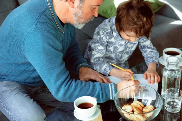 El abuelo y su nieto pasan tiempo aislados en casa, estudiando