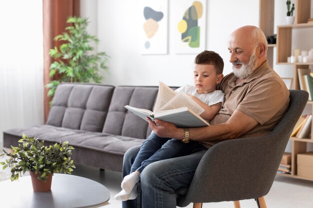 Abuelo de tiro medio leyendo a niño