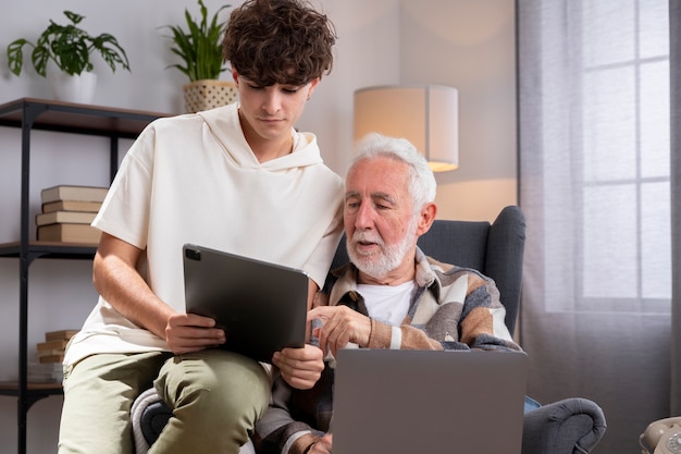 Abuelo de tiro medio y niño con dispositivos.