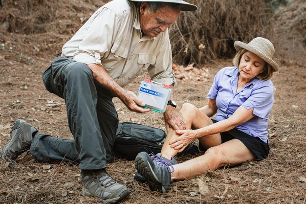 Abuelo usando botiquín de primeros auxilios para cuidar a la abuela