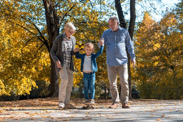 Abuelos felices jugando con su nieto en el parque