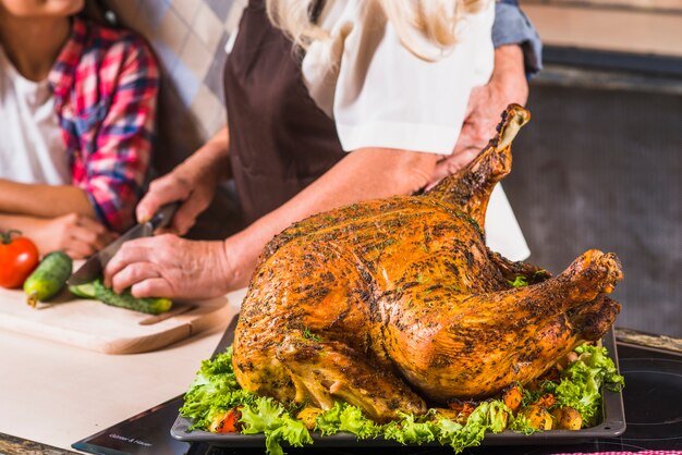 Abuelos con nieta cocinando pavo