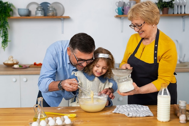 Foto gratuita abuelos y niña de tiro medio en la cocina