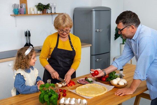 Foto gratuita abuelos y niña de tiro medio en la cocina