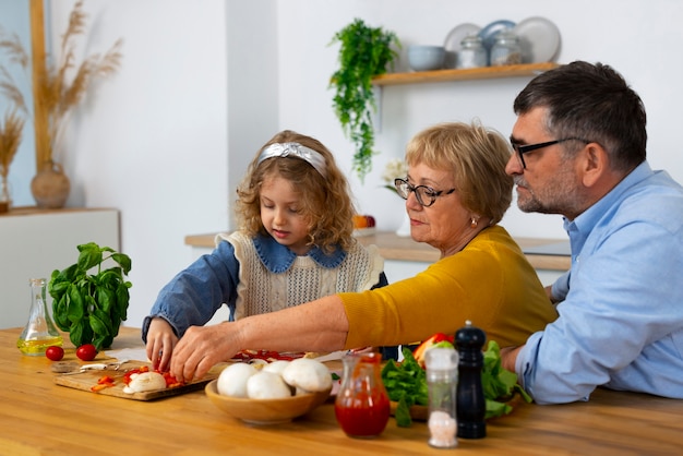 Foto gratuita abuelos y niña de tiro medio en la cocina