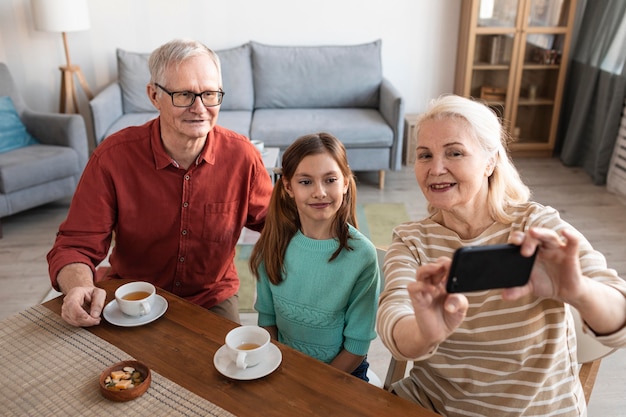 Foto gratuita abuelos y niña tomando selfie