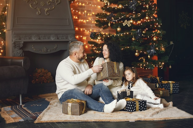 Abuelos sentados con su nieta. Celebrando la Navidad en una casa acogedora.