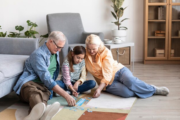 Foto gratuita abuelos de tiro completo y niños haciendo rompecabezas