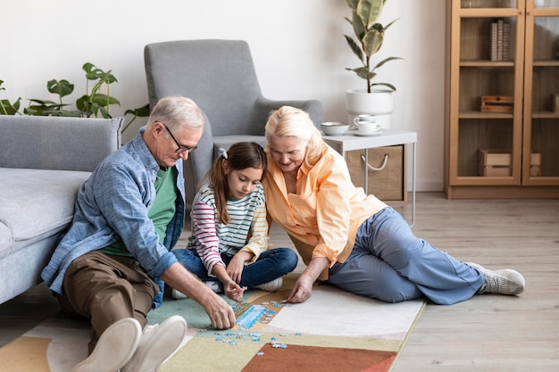 Abuelos de tiro completo y niños haciendo rompecabezas