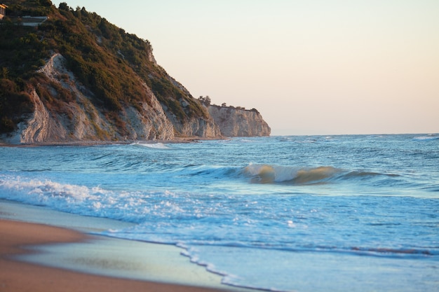 Foto gratuita acantilado y una roca en la playa del mar en un día soleado