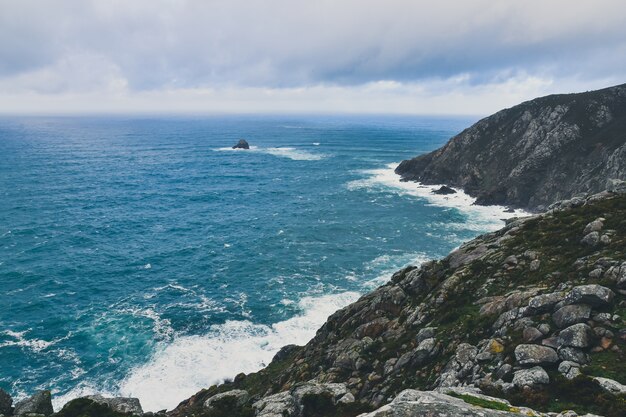 Acantilado rocoso del Cabo Finisterre en Galicia, España bajo un cielo nublado