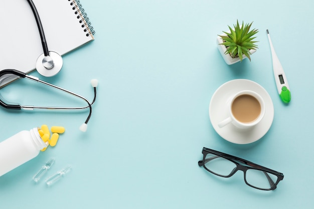 Accesorios para el cuidado de la salud; taza de café y gafas sobre fondo azul