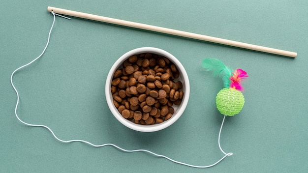 Accesorios para mascotas bodegón con juguete y tazón de comida.