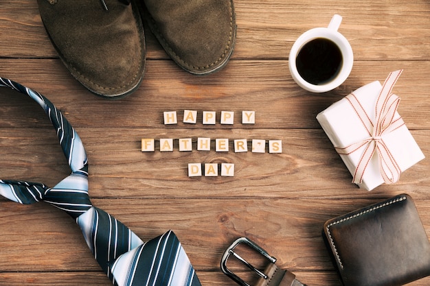 Accesorios masculinos cerca de las palabras presentes y felices del día del padre.