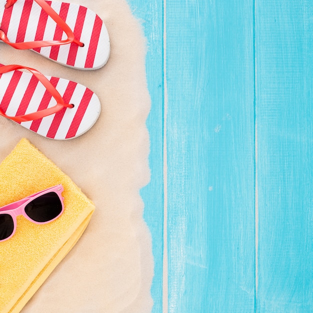 Foto gratuita accesorios de playa en tablón azul y arena - fondo de vacaciones de verano