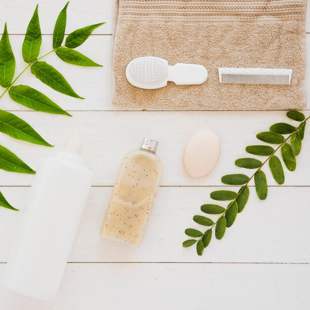 Accesorios para la salud de la piel en la mesa con hojas verdes