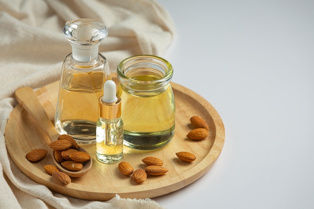 Aceite de almendras en botella sobre fondo blanco.