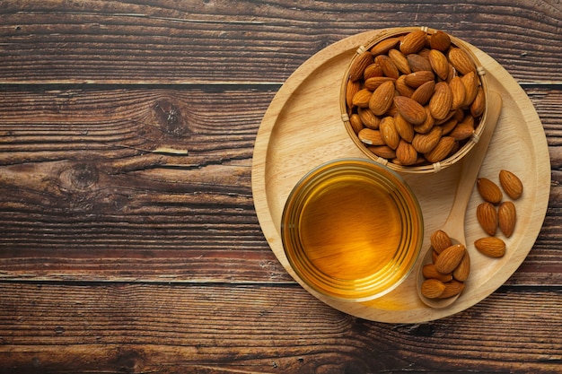 Aceite de almendras en botella sobre fondo de madera oscura.